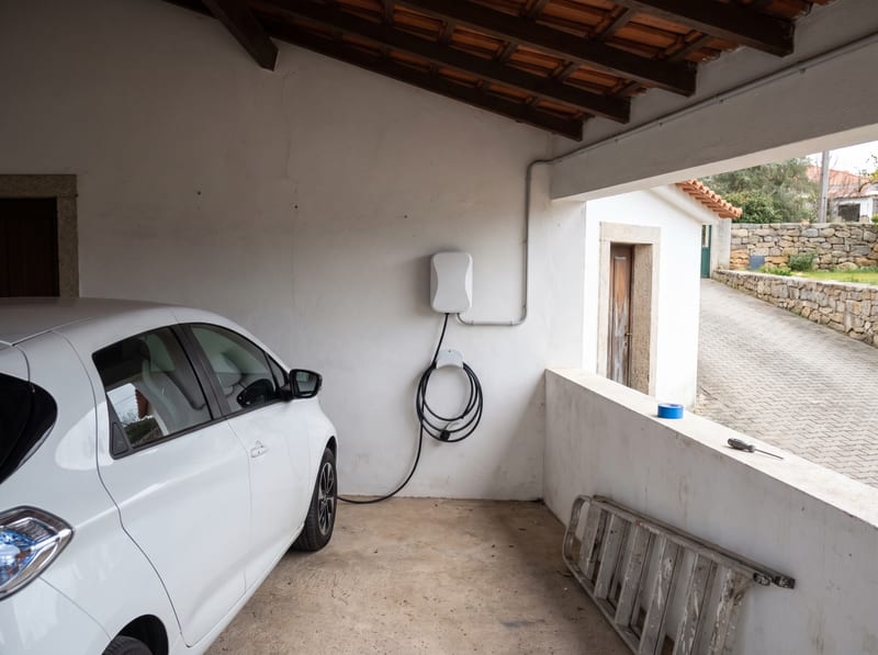 Carregador de parede instalado num alpendre de moradia, abrigado da chuva